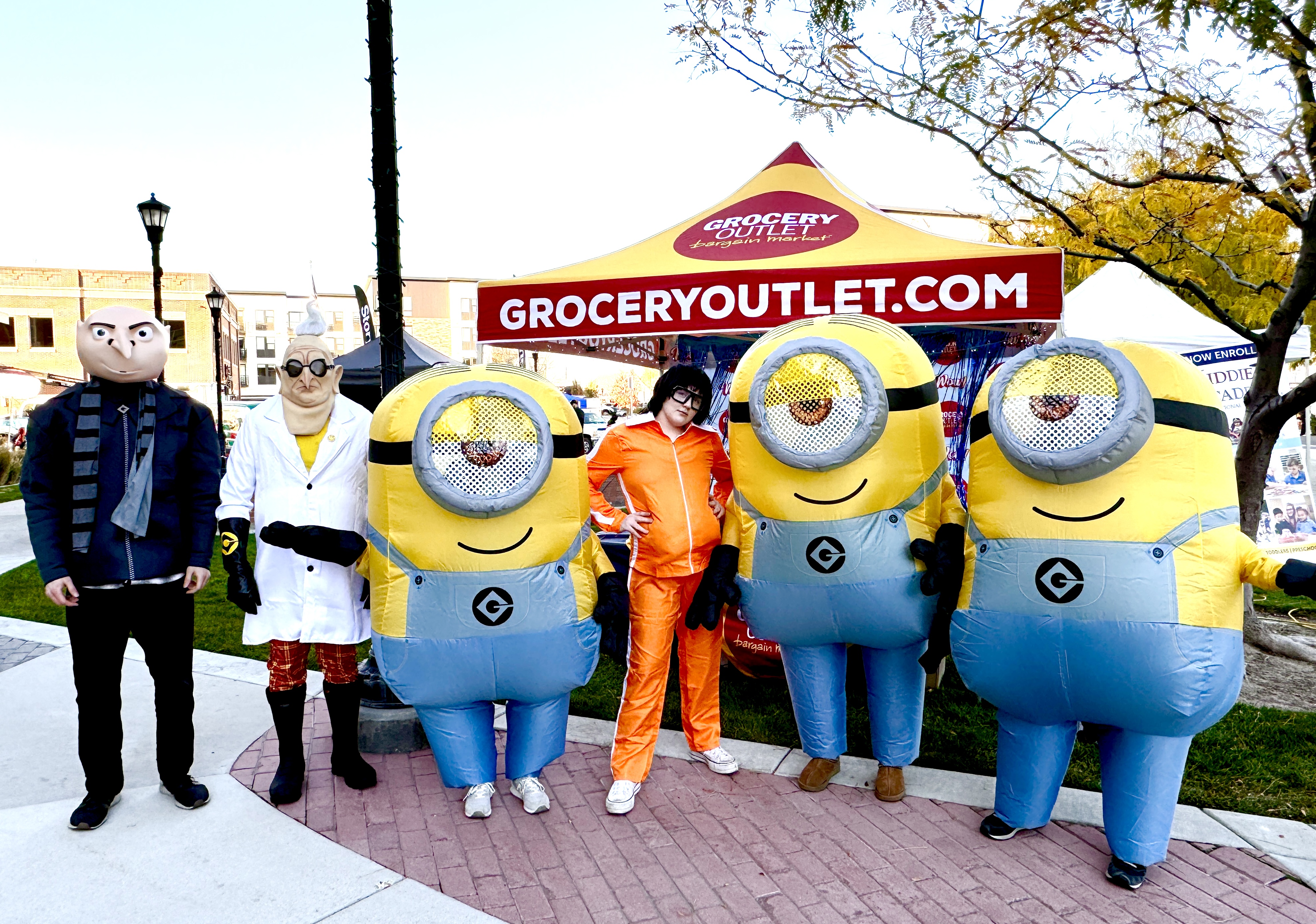 People dressed up a the Minions in front of a Grocery Outlet Booth at Trunk or Treat